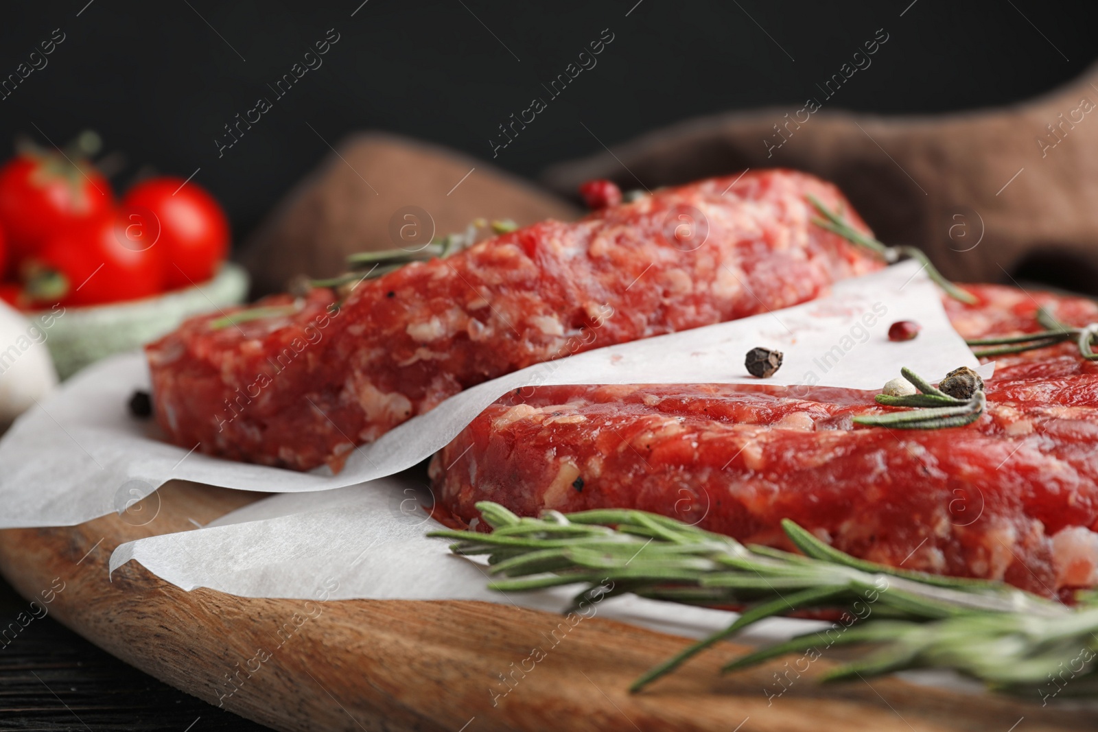 Photo of Raw meat cutlets for burger on wooden board, closeup