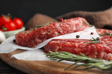 Raw meat cutlets for burger on wooden board, closeup