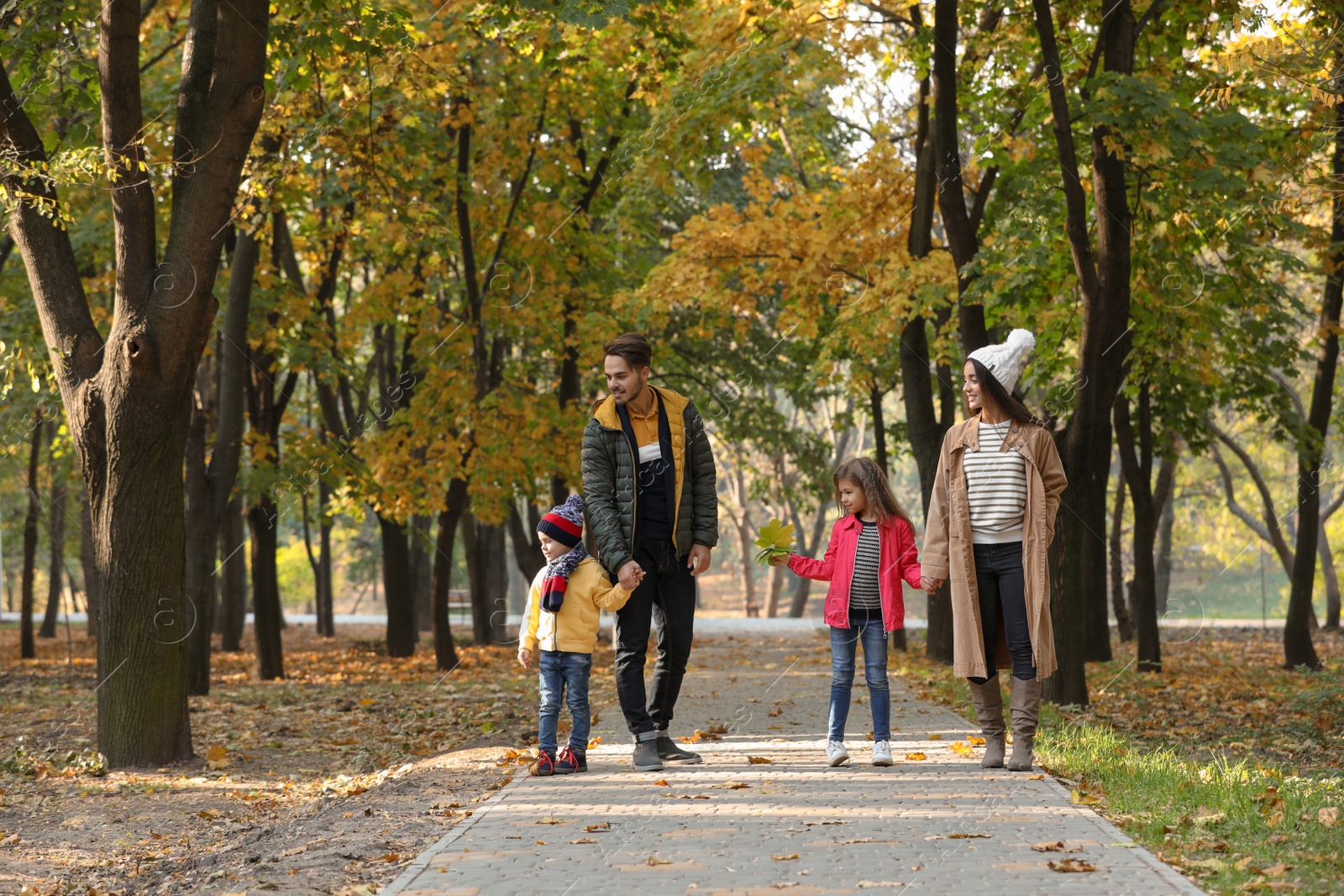 Photo of Happy family with children spending time together in park. Autumn walk