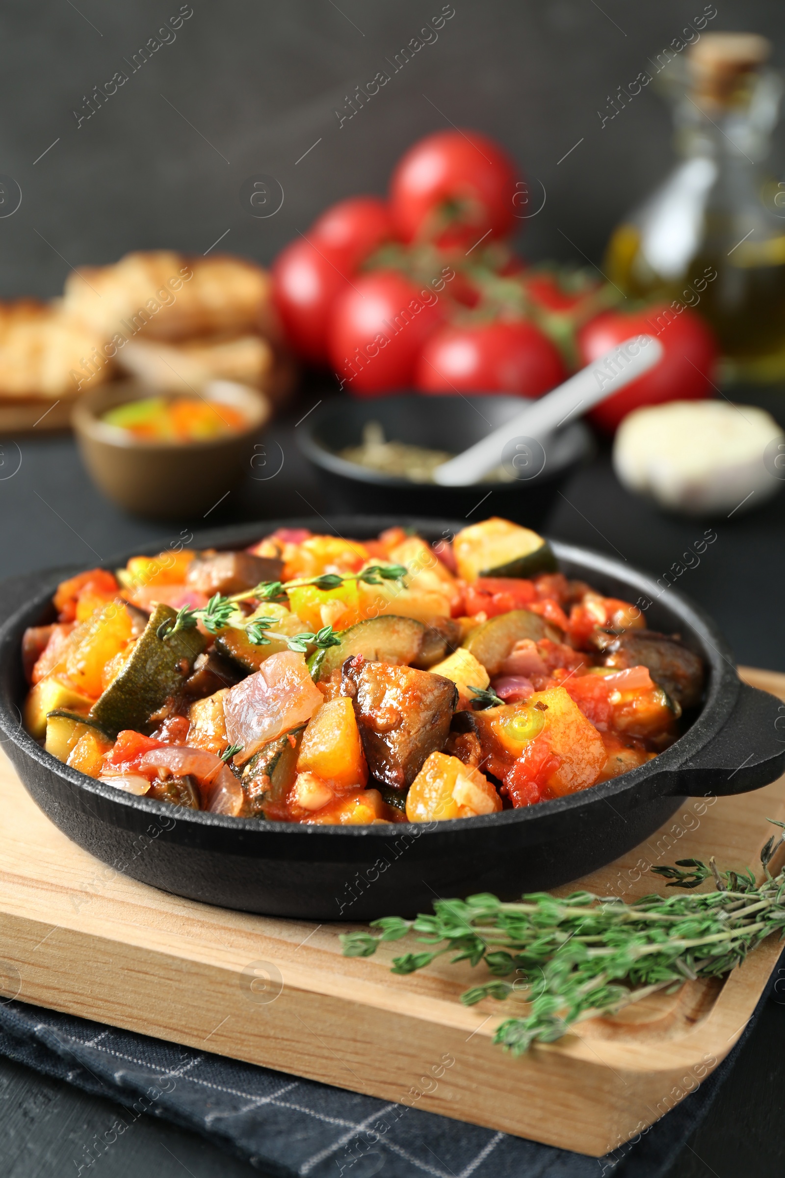 Photo of Dish with tasty ratatouille on wooden board