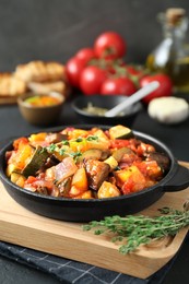 Photo of Dish with tasty ratatouille on wooden board