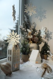 Many beautiful Christmas decorations and fir branches on window sill indoors