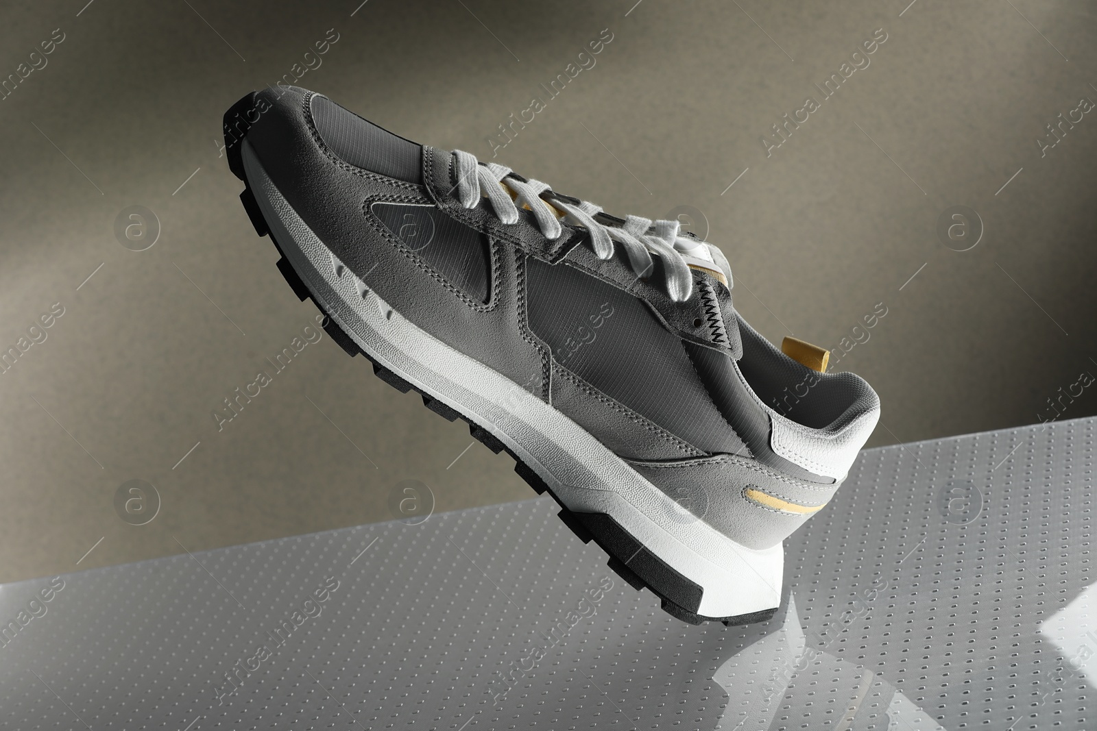 Photo of Stylish presentation of trendy sneaker against grey background