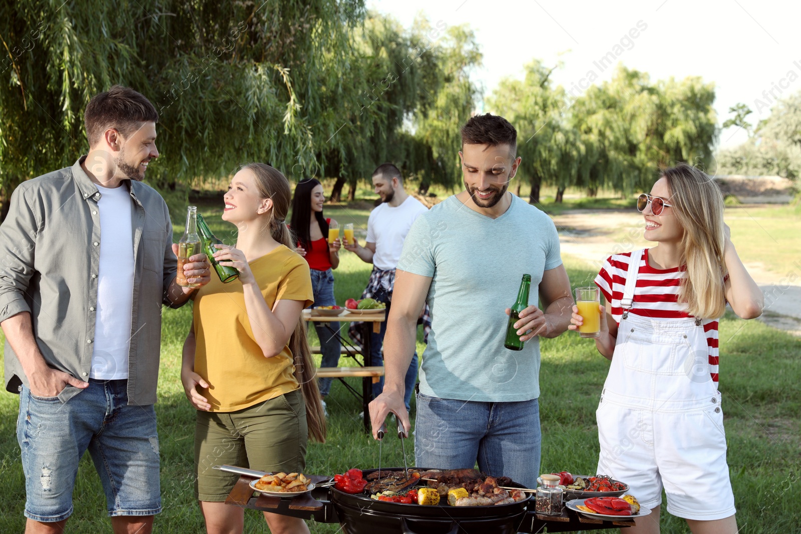 Photo of Group of friends having barbecue party in park