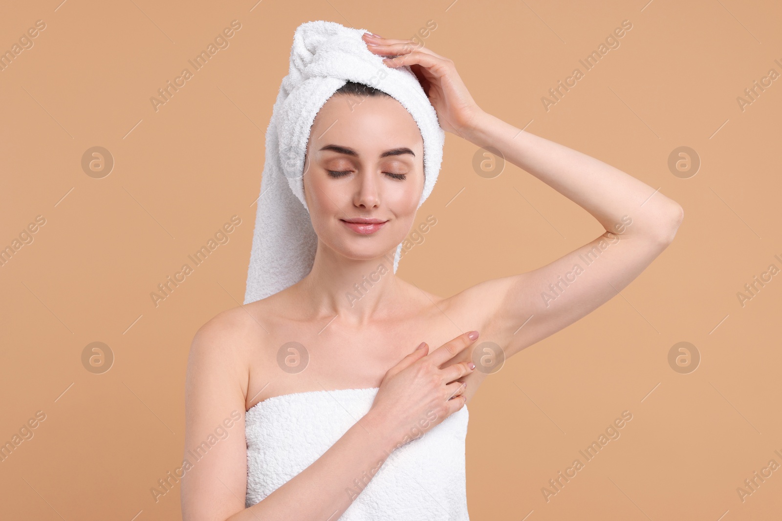 Photo of Beautiful woman showing armpit with smooth clean skin on beige background