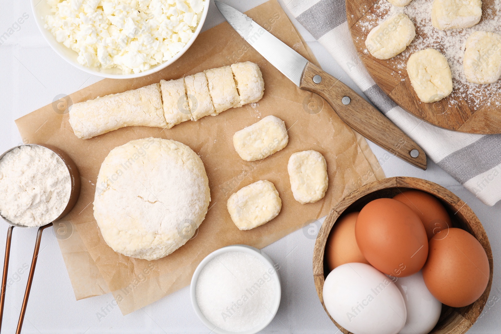 Photo of Making lazy dumplings. Raw dough, ingredients and knife on white tiled table, flat lay