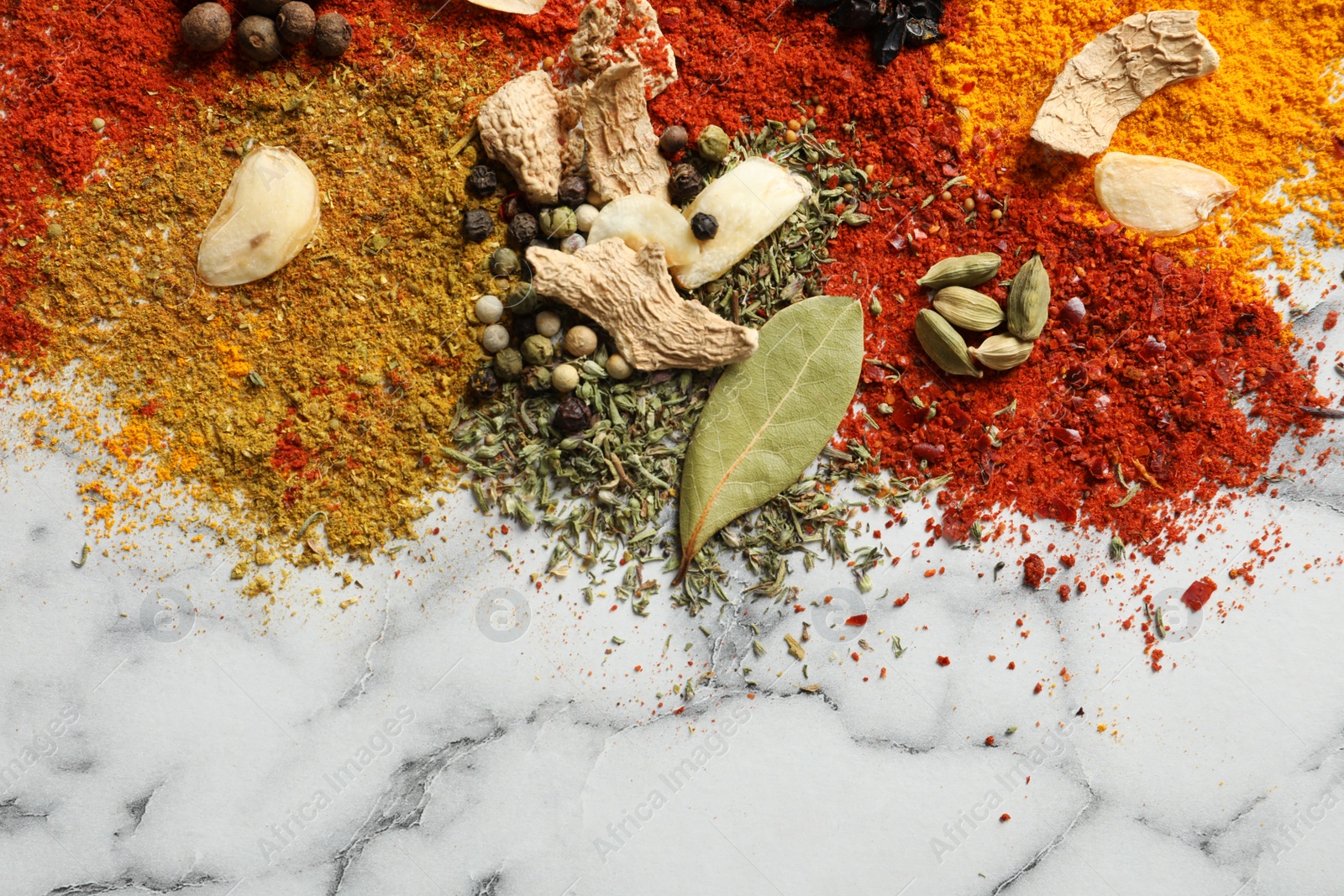 Photo of Different aromatic spices on marble background, top view with space for text