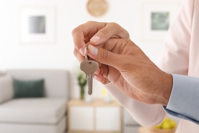 Couple holding key on blurred background. Real estate agent services