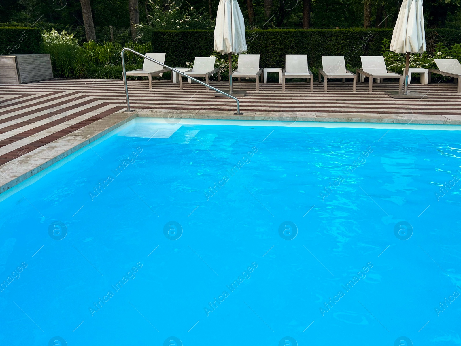 Photo of Outdoor swimming pool in luxury hotel on sunny summer day. Time for relax