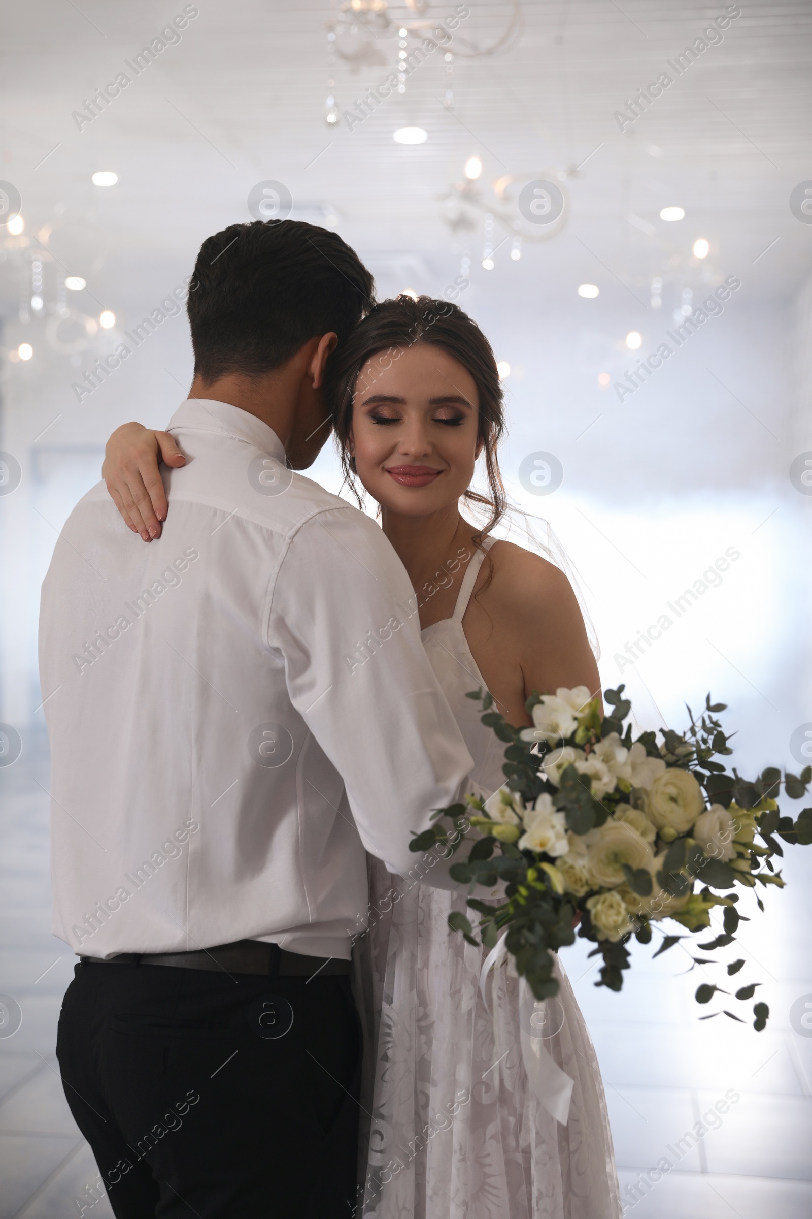 Photo of Happy newlywed couple dancing together in festive hall