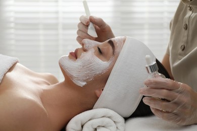 Young woman during face peeling procedure in salon