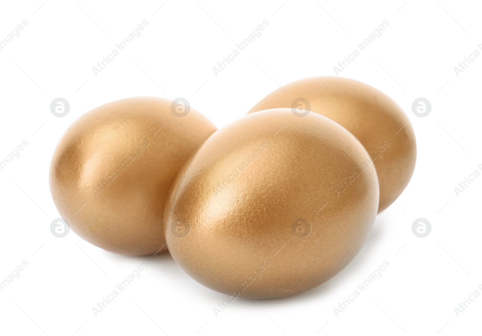 Photo of Three shiny golden eggs on white background