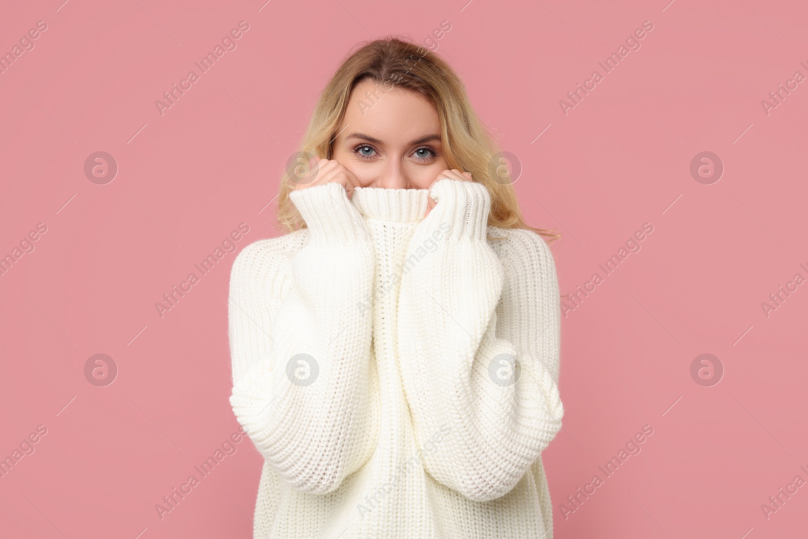 Photo of Beautiful woman in stylish warm sweater on pink background