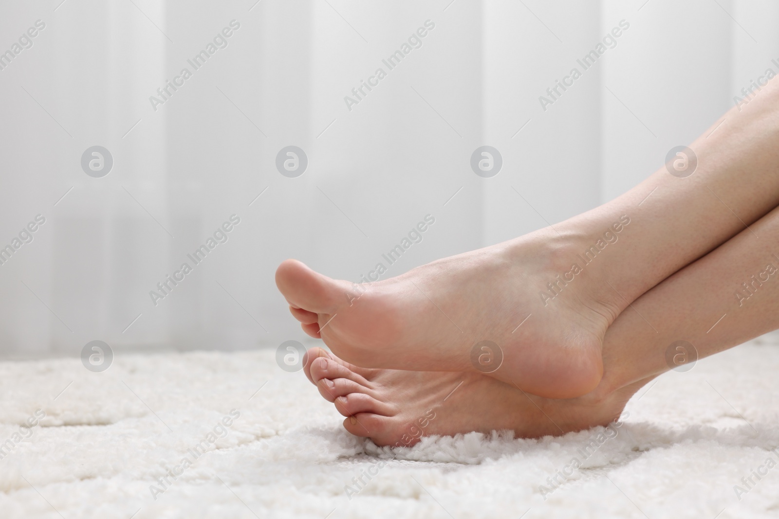 Photo of Woman on soft white carpet at home, closeup. Space for text