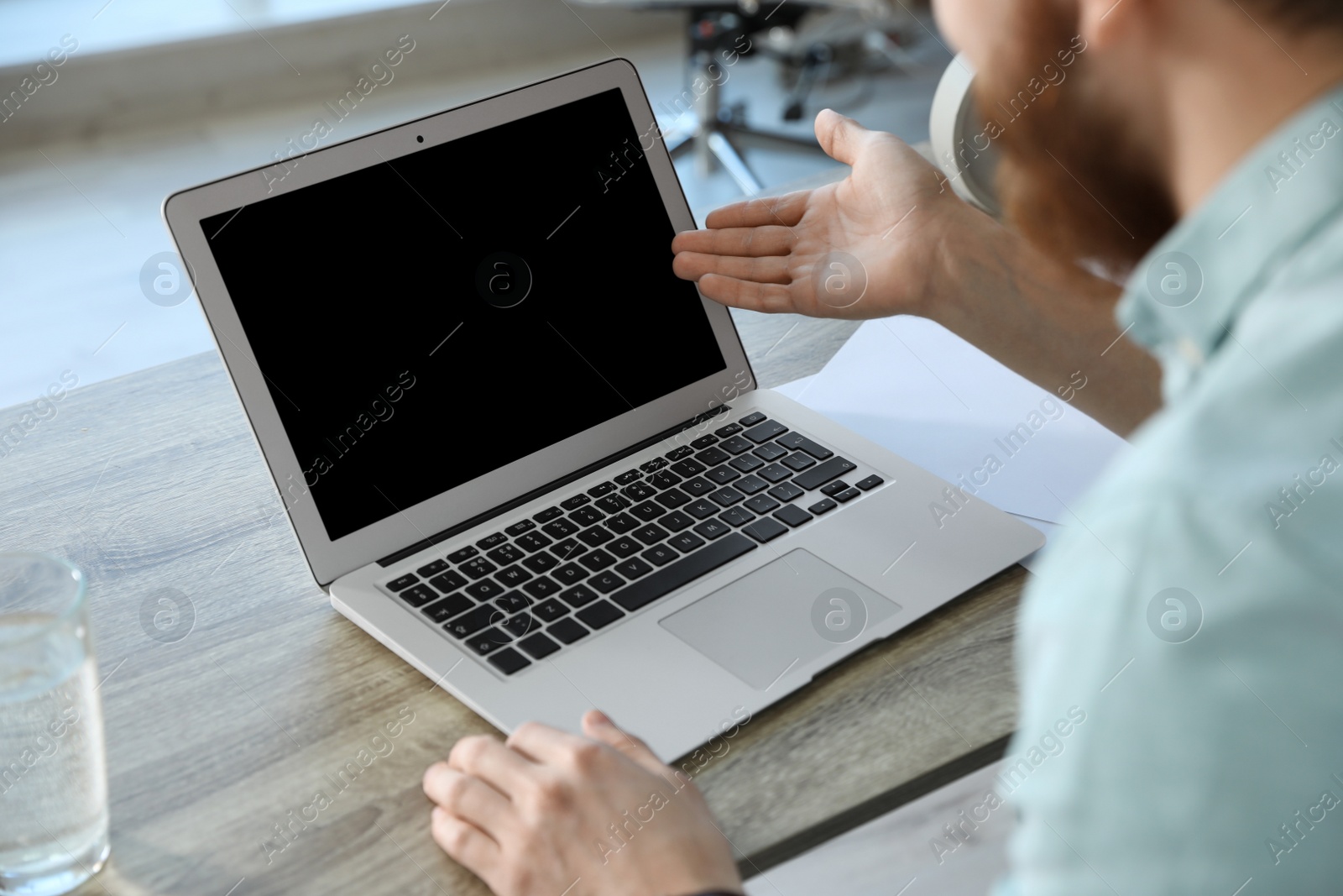 Photo of Man using video chat on laptop in home office, closeup. Space for text