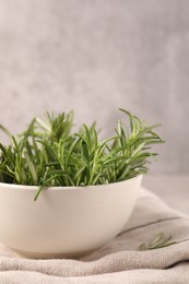 Photo of Bowl with fresh green rosemary on towel