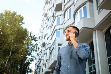 Young man talking on smartphone on city street