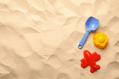 Flat lay of beach toy kit on sand, space for text. Outdoor play