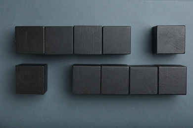 Flat lay composition with black cubes on dark background. Pareto principle concept