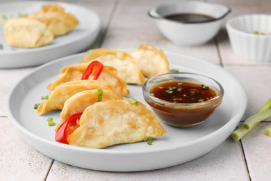 Photo of Delicious gyoza (asian dumplings) with sauce on table, closeup