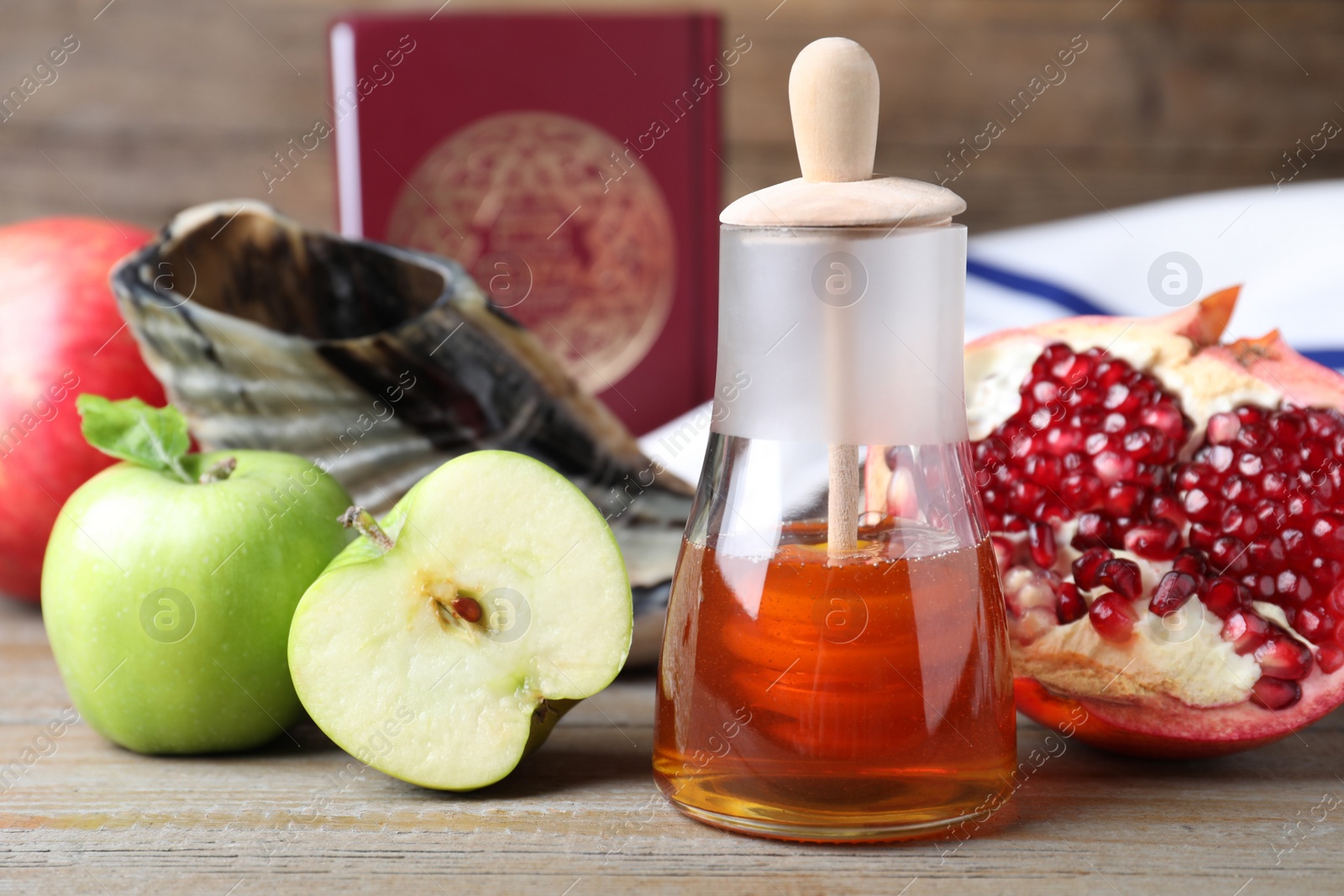 Photo of Honey, pomegranate, apples, shofar and Torah on wooden table. Rosh Hashana holiday