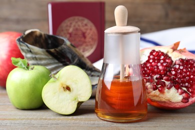 Honey, pomegranate, apples, shofar and Torah on wooden table. Rosh Hashana holiday