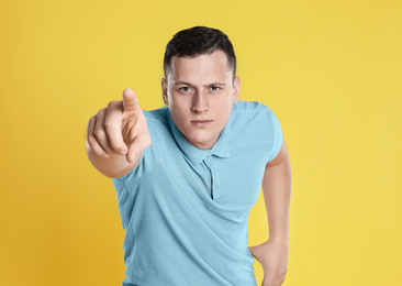 Photo of Grumpy young man posing on yellow background