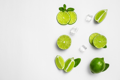 Photo of Flat lay composition with fresh juicy limes, mint and ice cubes on white background