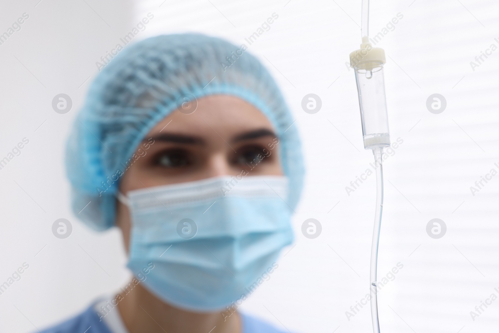 Photo of Setting up IV drip. Nurse on blurred background, selective focus