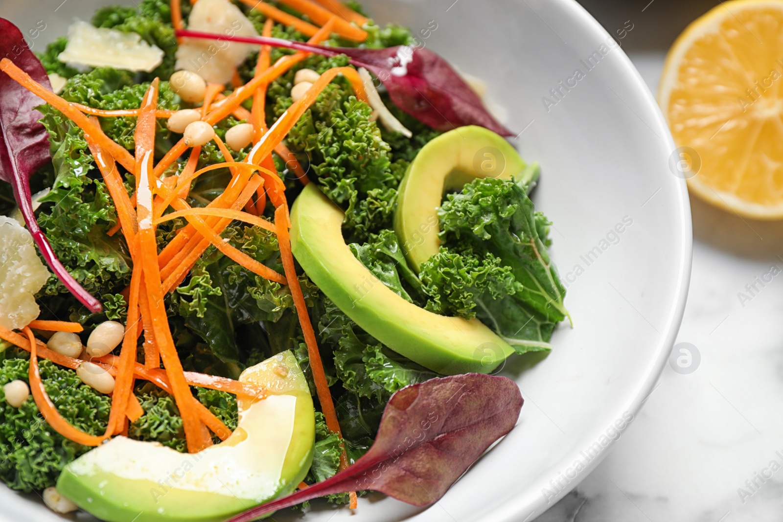 Photo of Tasty fresh kale salad on marble table, closeup