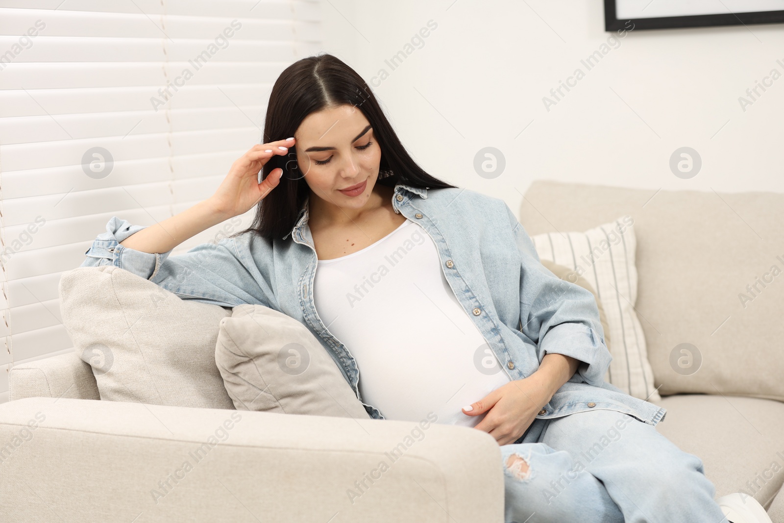 Photo of Pregnant young woman on sofa at home