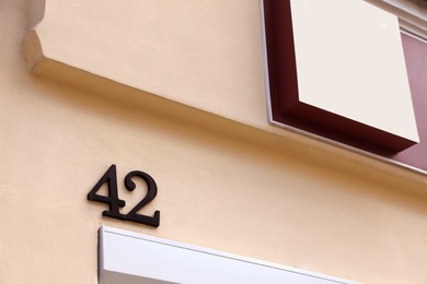 Photo of House number 42 on beige wall outdoors