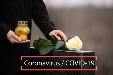 Funeral ceremony devoted to coronavirus victims. Woman with candle and rose near tombstone outdoors, closeup.