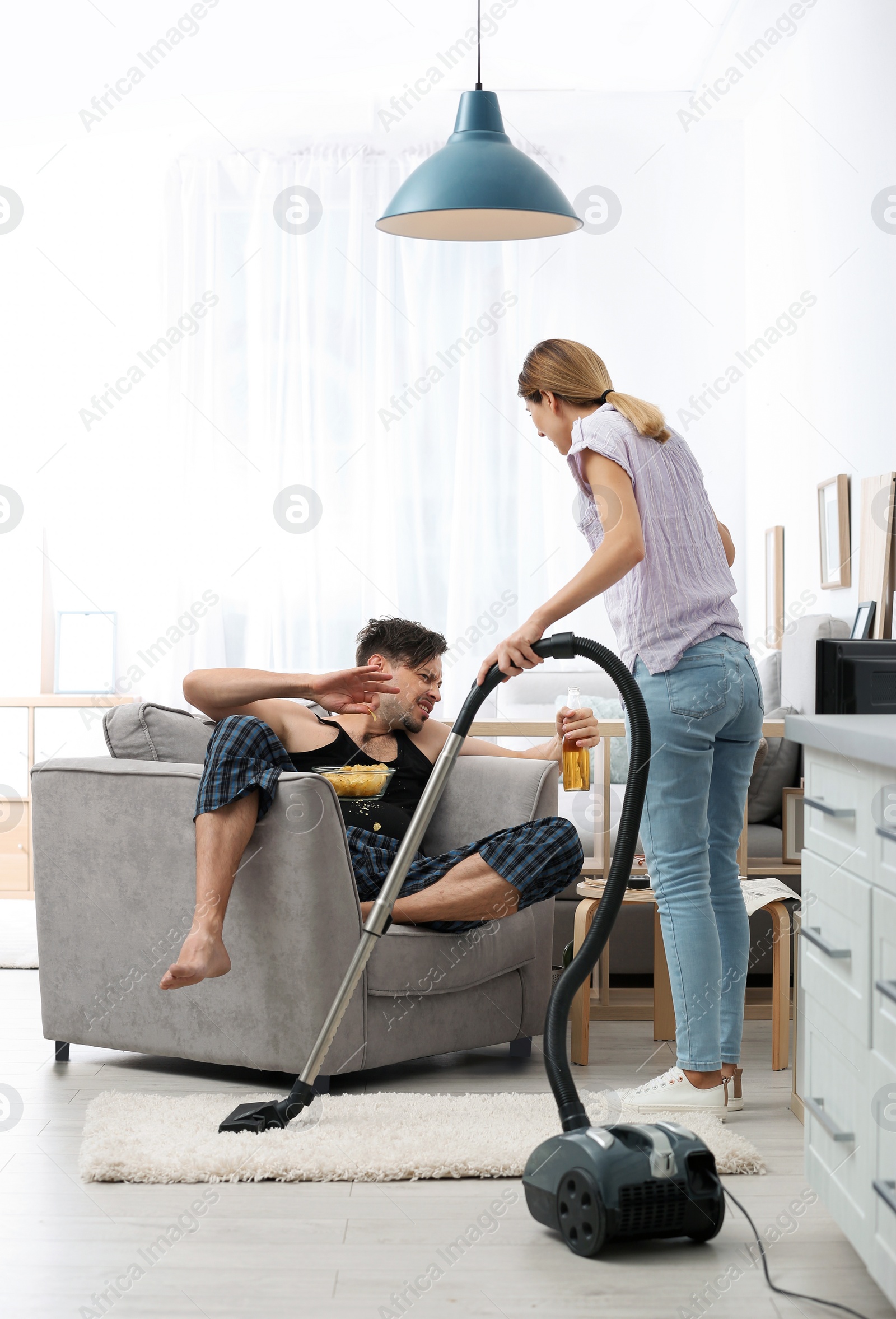 Photo of Lazy husband quarrelling with hardworking wife at home