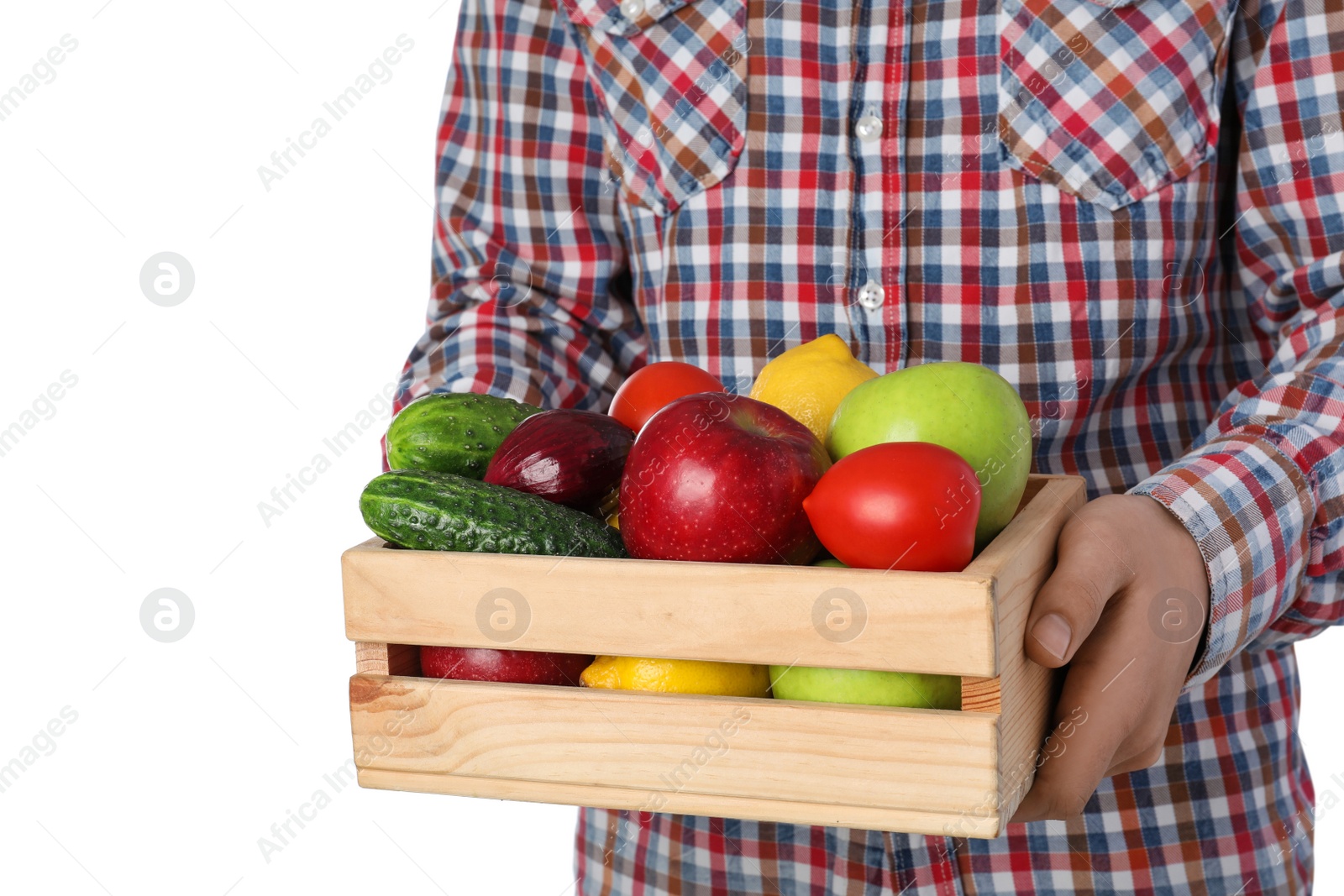 Photo of Man holding wooden crate filled with fresh vegetables and fruits against white background, closeup