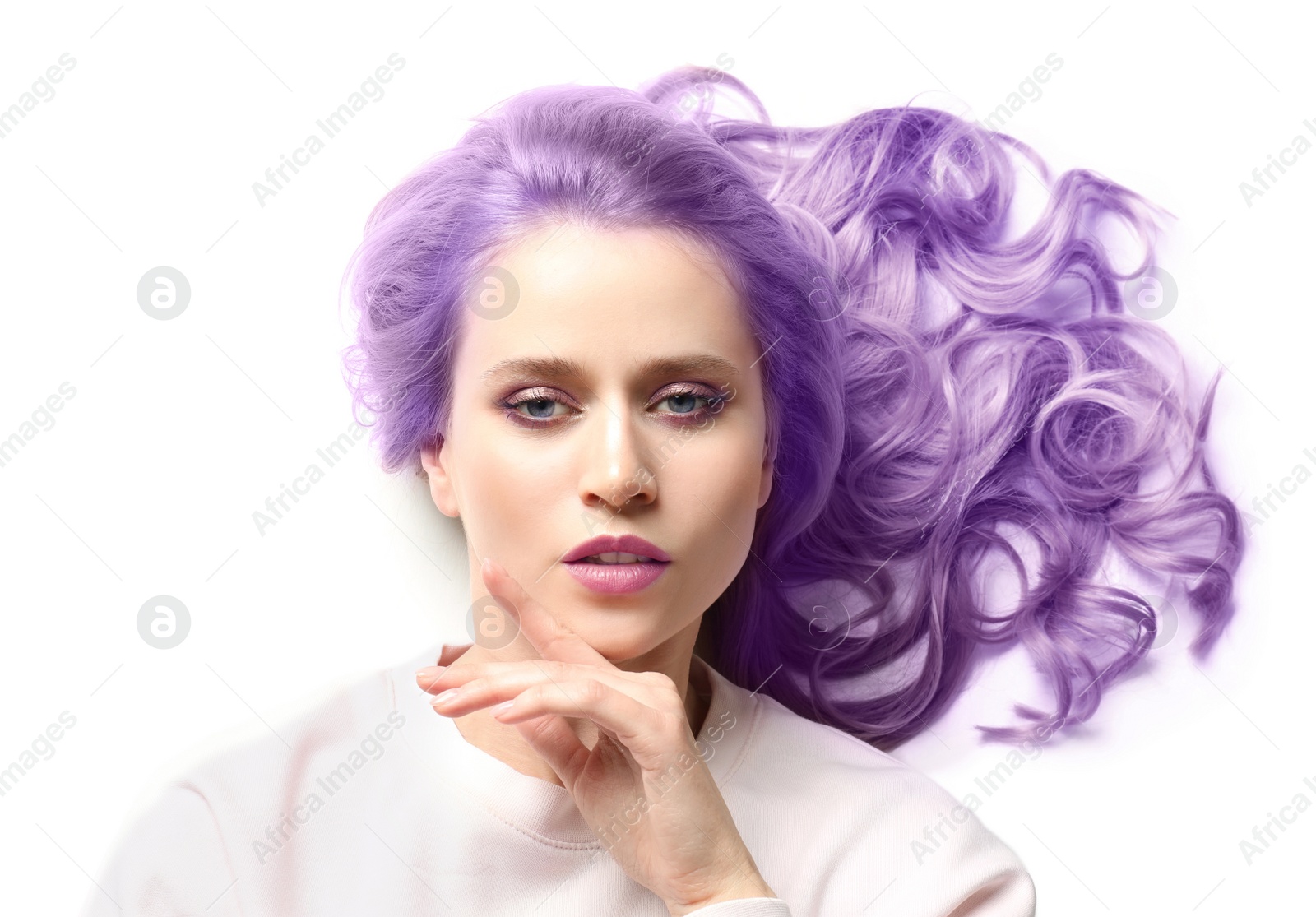 Image of Portrait of young woman with dyed long curly hair on white background