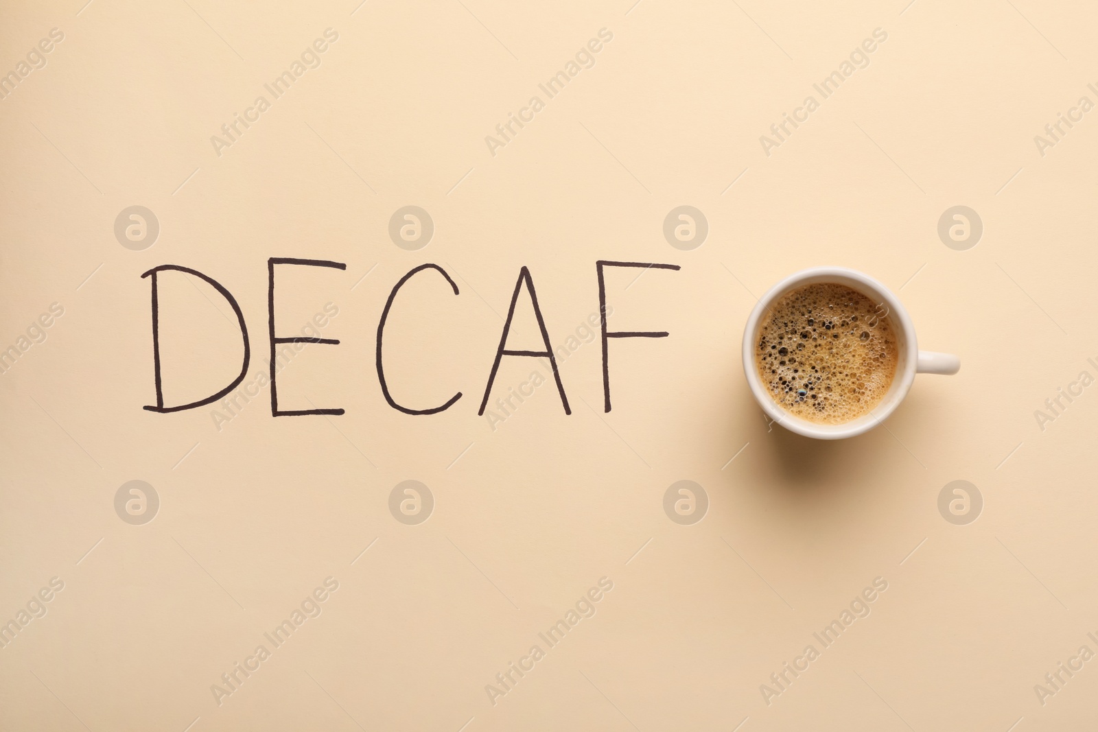 Photo of Cup of aromatic coffee and word Decaf on beige background, top view