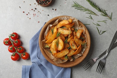 Photo of Tasty baked potatoes served with rosemary on table, flat lay