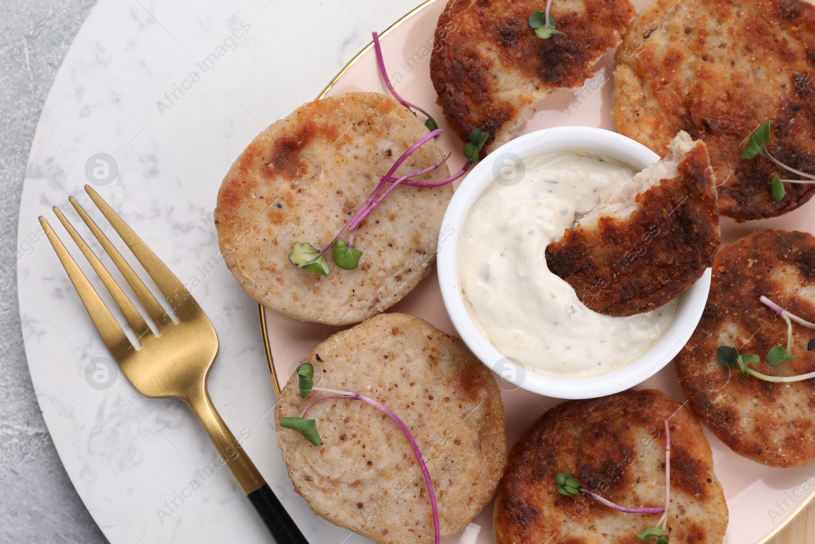 Photo of Delicious vegan cutlets and sauce on light grey table, top view