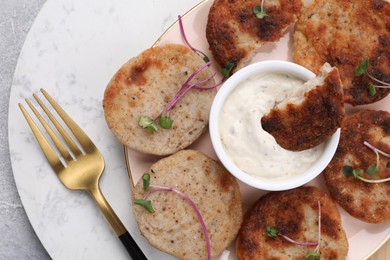 Delicious vegan cutlets and sauce on light grey table, top view