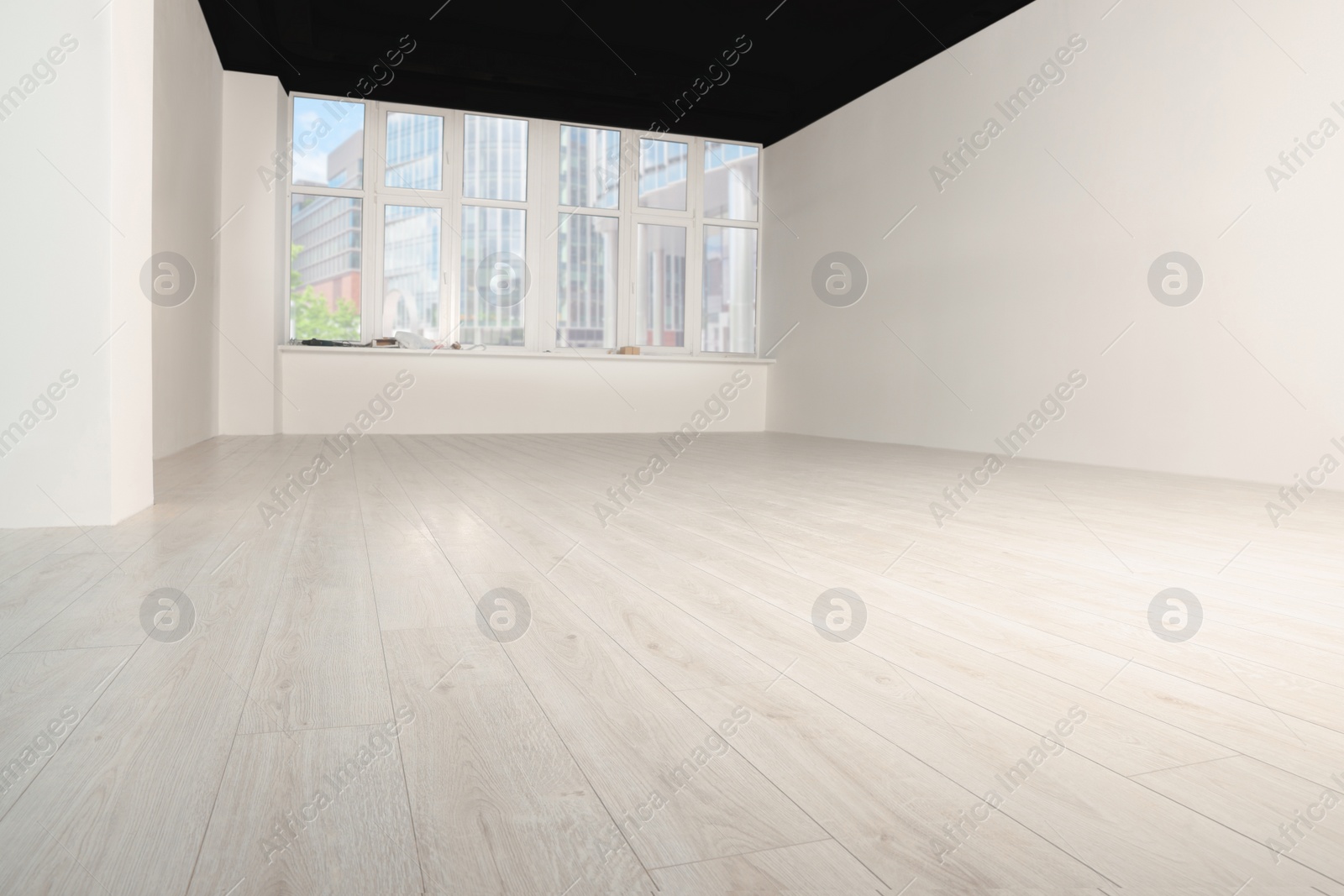 Photo of Empty room with new white laminated flooring