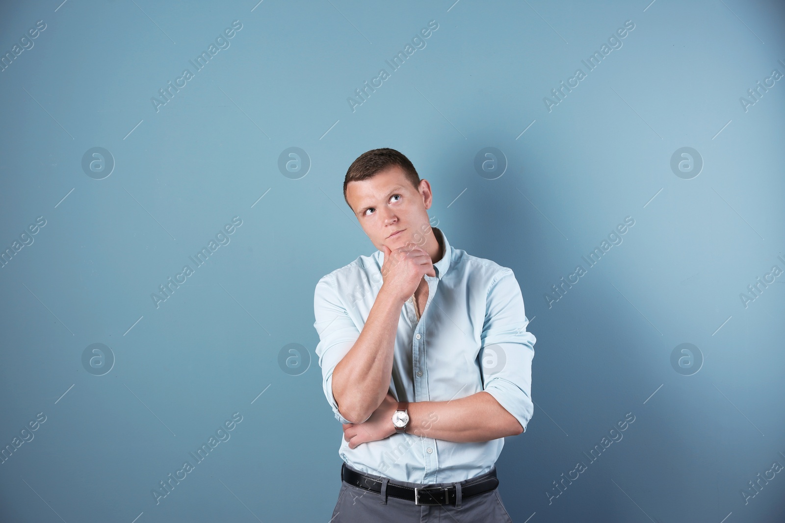 Photo of Thoughtful handsome young man on color background