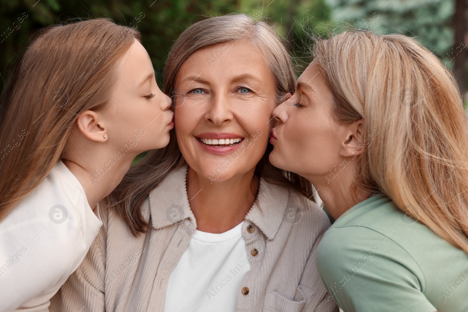 Photo of Three generations. Happy grandmother, her daughter and granddaughter outdoors