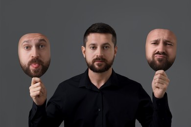 Man holding masks with his face showing different emotions on grey background. Balanced personality