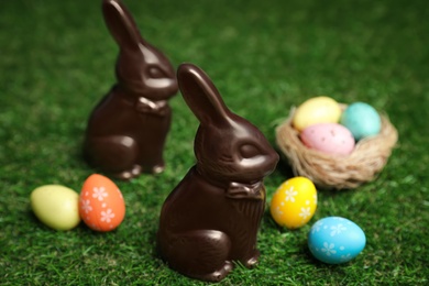 Chocolate bunnies and eggs on green grass. Easter celebration