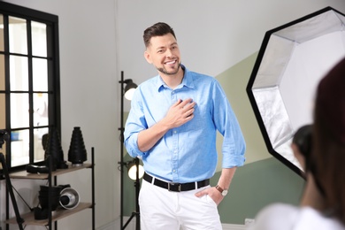 Photo of Handsome model posing for professional photographer in studio