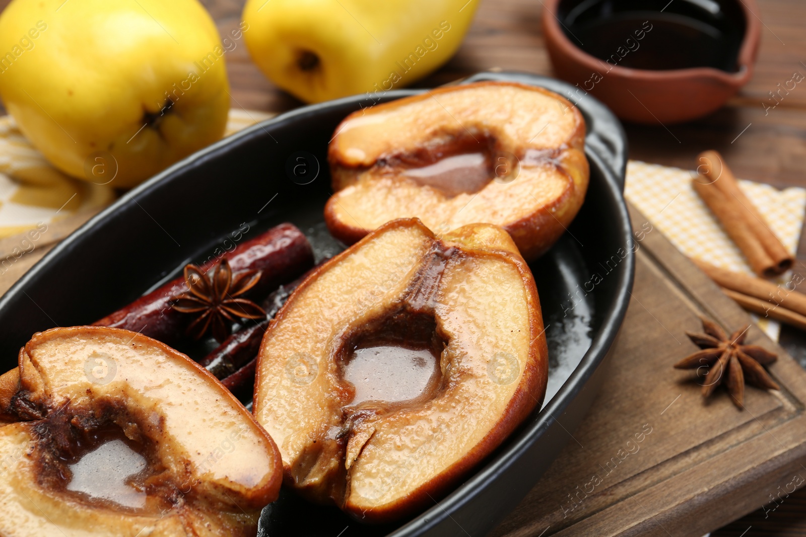 Photo of Tasty baked quinces with spices and honey in dish on table, closeup