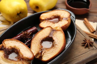 Photo of Tasty baked quinces with spices and honey in dish on table, closeup