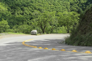 Photo of Asphalt road with yellow line near trees outdoors