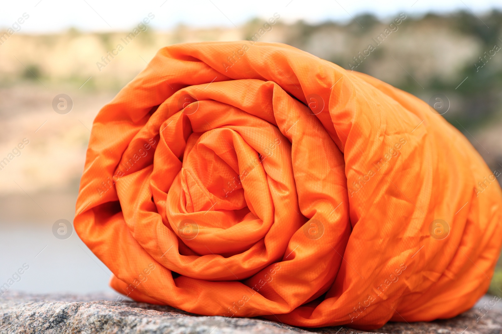 Photo of Rolled sleeping bag outdoors on sunny day, closeup